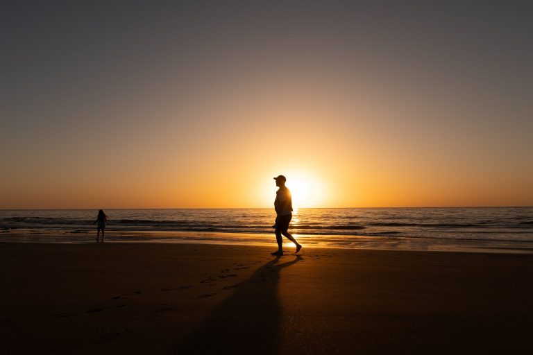 imagen ritmos circadianos hombre paseando en la playa al amanecer